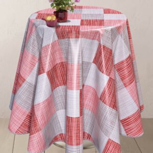 Round table covered with a red, white, and gray checkered wipe clean PVC vinyl tablecloth, adorned with a small vase of purple flowers and a bowl of biscuits